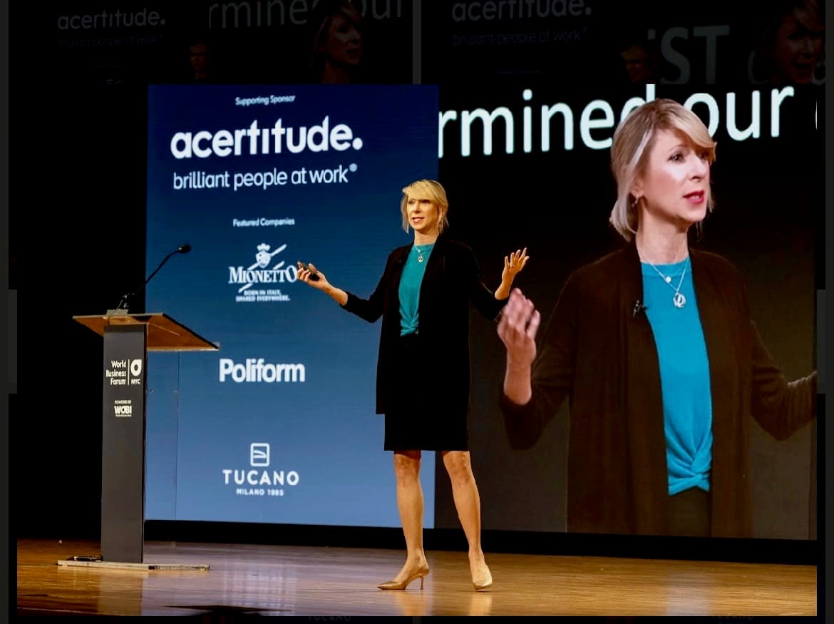 Amy Cuddy on stage, arms raised